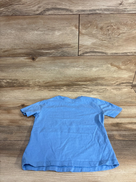 Light blue short-sleeve kids t-shirt laid flat on wooden surface at children's resale store