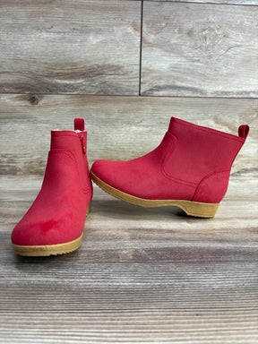Pair of red toddler ankle boots with side zippers on wooden background