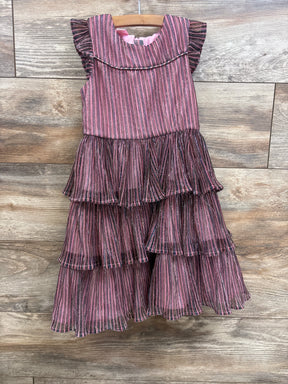 Pink and black striped tiered ruffle dress for girls, hanging on wooden hanger against wood floor