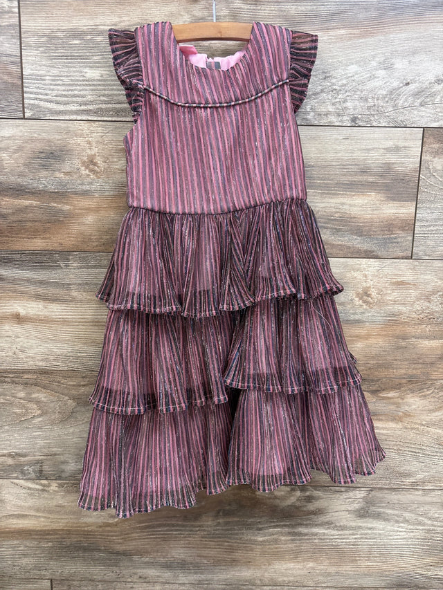 Pink and black striped tiered ruffle dress for girls, hanging on wooden hanger against wood floor