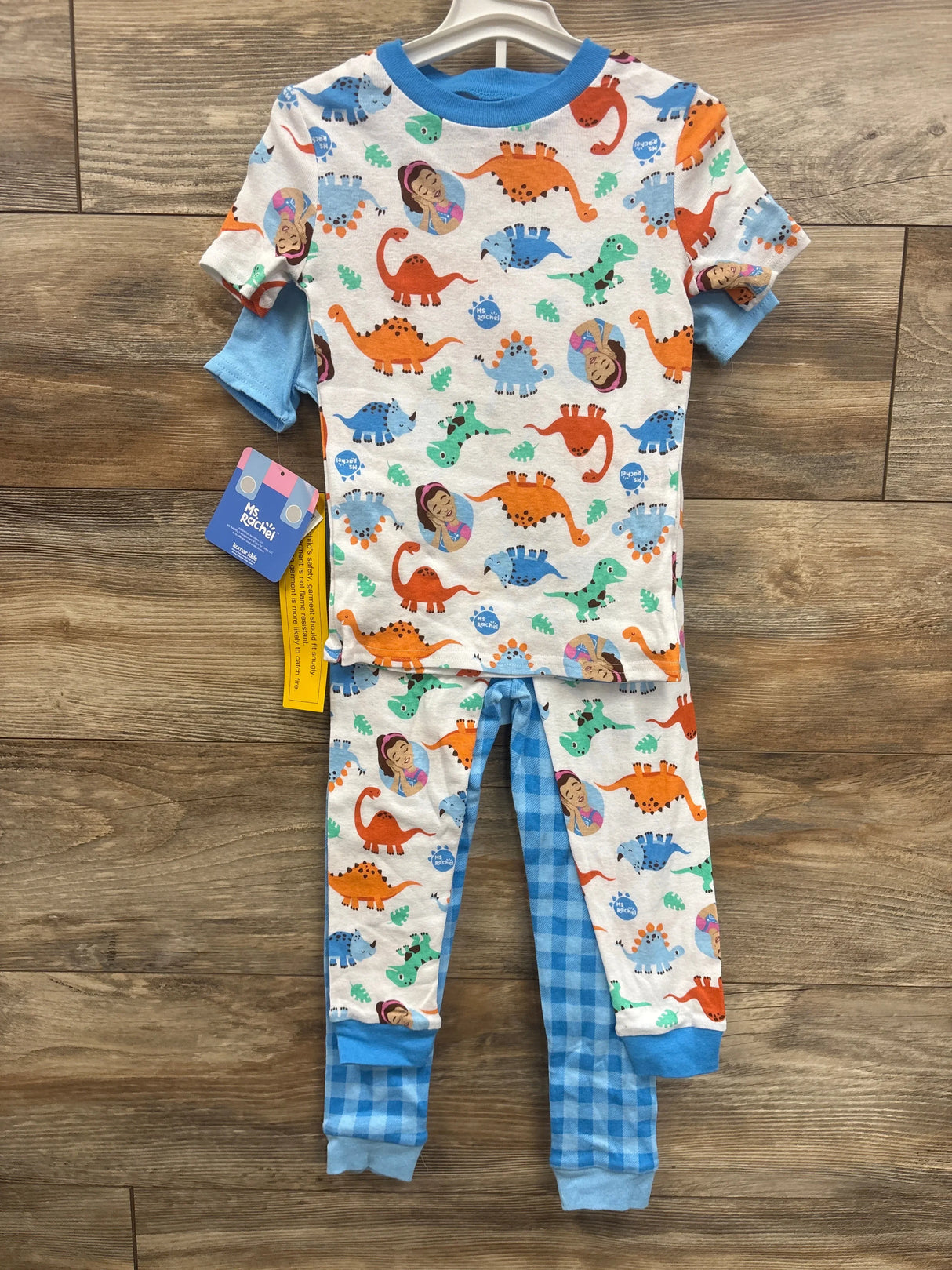 Colorful dinosaur print kids pajamas with blue trim, perfect for toddler sleepwear or bedtime comfort.