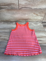 Flat lay of girls ribbed tank top showing pink and orange horizontal stripes and lettuce-edge hem on wood background