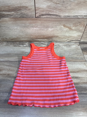 Flat lay of girls ribbed tank top showing pink and orange horizontal stripes and lettuce-edge hem on wood background