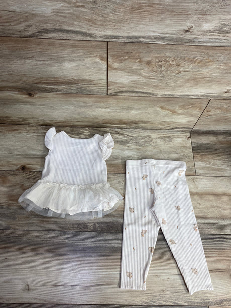 White baby outfit with ruffled sleeves and tutu top paired with ribbed leggings with teddy bear print on wood floor
