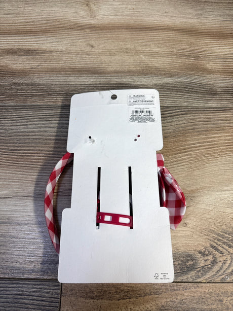 Top view of Gymboree headband and bow set with red-and-white gingham pattern on white cardboard backing