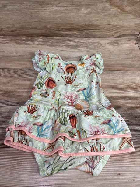 Top view of green sea animal bamboo bodysuit twirl dress showcasing flutter sleeves and pink trim on a wood surface