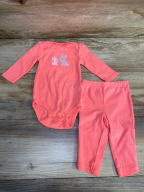 Top view of pink Simple Joys 2pc bodysuit and pants 3-6m with embroidered bunny on chest and elastic waist on wood surface