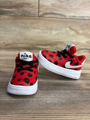 Red and black spotted Nike Force 1 toddler shoes with white soles on wooden surface