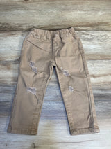 Light brown distressed kids pants with elastic waistband on wood floor
