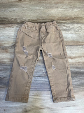 Light brown distressed kids pants with elastic waistband on wood floor
