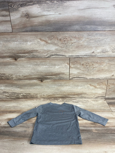 Back view of gray long-sleeve toddler shirt on wood floor background