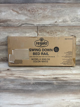 Front of boxed Regalo swing down bed rail showing large Swing Down Bed Rail label, 43 inch length and color white on wood-plank background