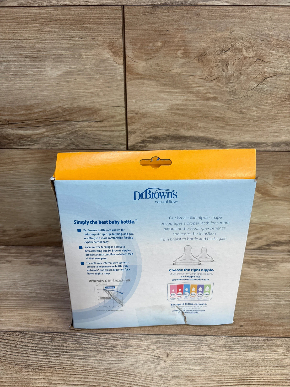 Back of Dr Browns 3-pack wide-neck 9 oz bottle box showing Level 1 slow-flow nipple and anti-colic info on wood background