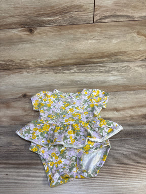 Flat-lay of Carter's floral skirted bodysuit, 3M, showcasing short sleeves, ruffle skirt and snap crotch on light wood floor