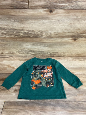Green toddler long sleeve shirt with dinosaur Halloween graphic saying 'More Candy Please!' on wood floor