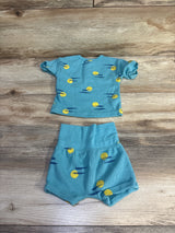 Flat lay of teal 2-piece waffle knit henley shirt and shorts set, size 0-3M, with yellow sun print on wood background