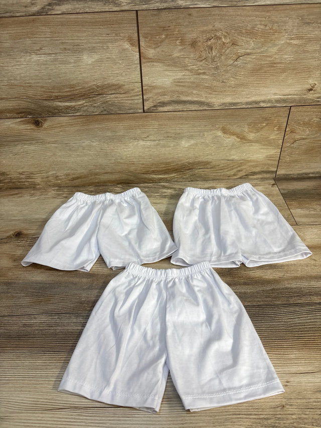 Three pairs of white kids' shorts with elastic waistbands on wood floor, perfect for baby or toddler clothing resale.