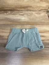 Front view of newborn blue Modern Moments drawstring shorts with elastic waist, white tie, ribbed fabric on wood