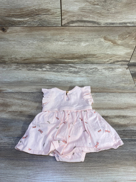 Flat lay of newborn pink ribbed bodysuit dress with flutter sleeves and dragonfly print skirt on wood plank background