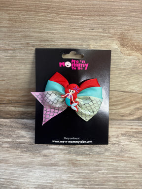 Front view of red and turquoise mermaid applique hair bow with iridescent mermaid-scale tails and mermaid charm on black card