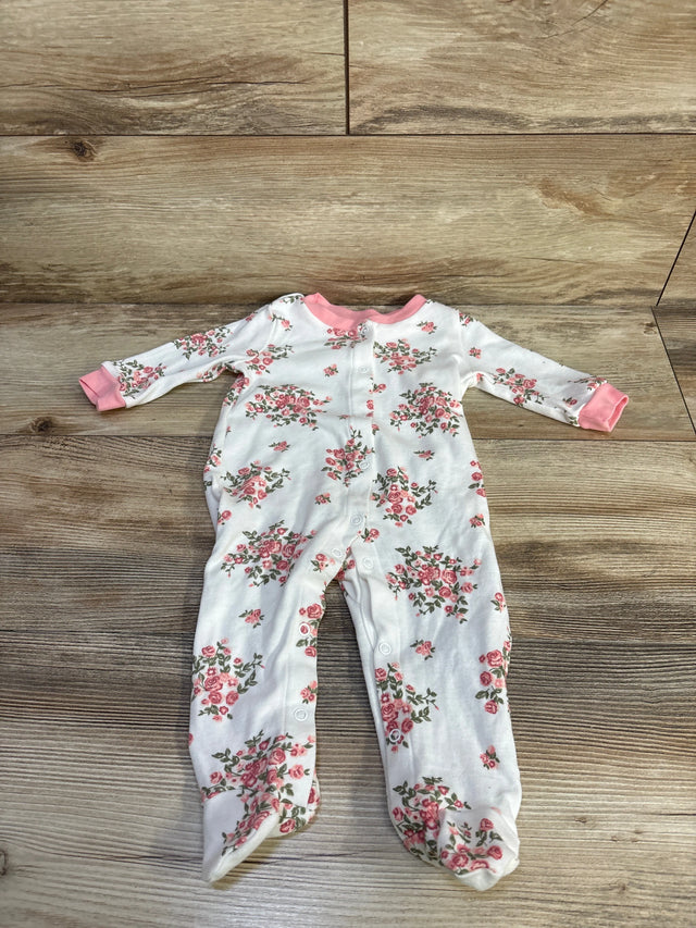 Flat lay of white floral footed baby sleeper (3-6 months) showing pink rose print and front snap closures on wood background
