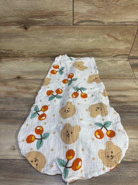 Flat lay of size Small (0-6M) white gauze sleep sack showing orange cherry and tan bear-face print on wood background