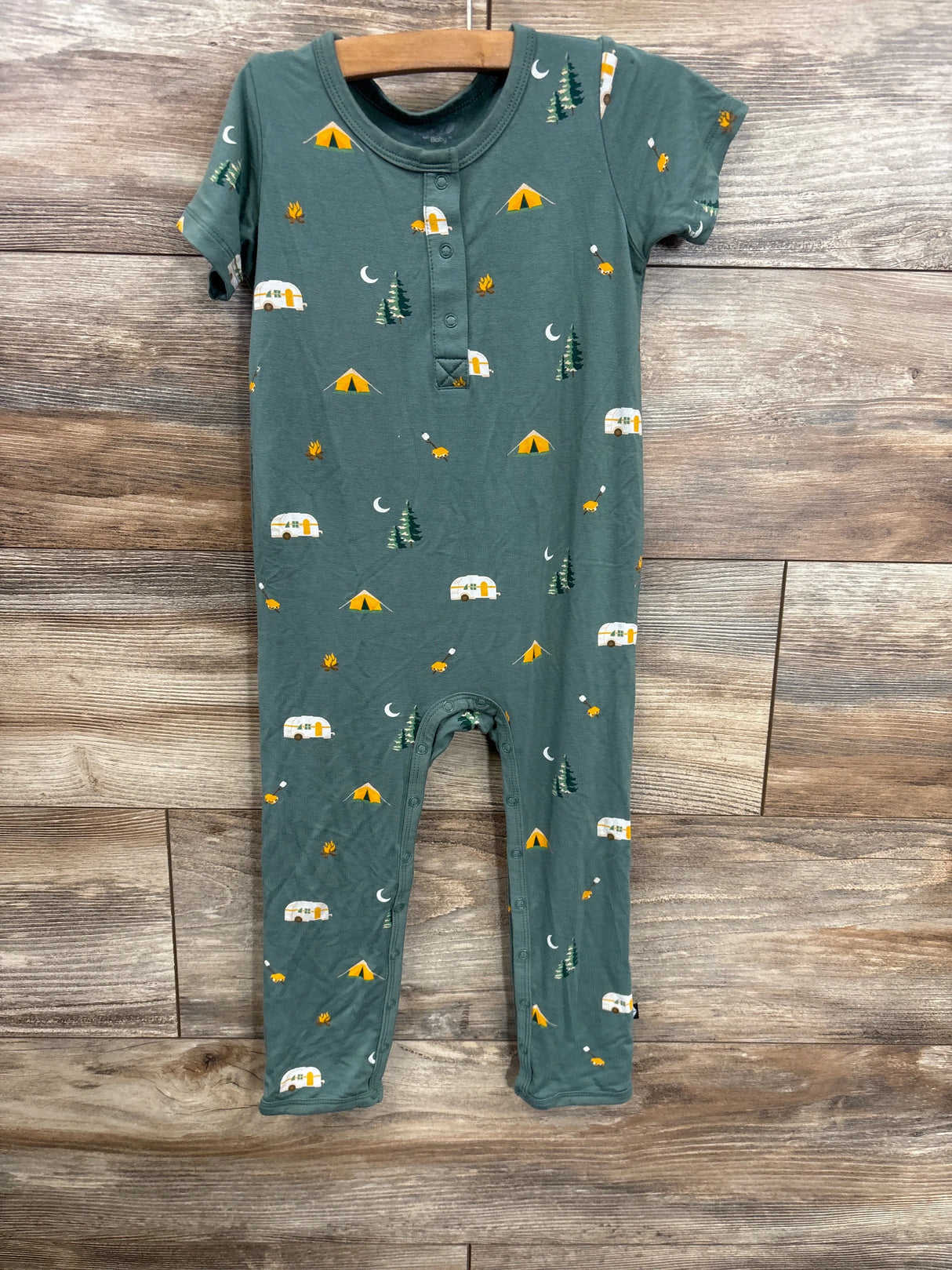 Green baby romper with camping print, tents, trees, trailers, and campfires
