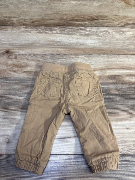 Cat & Jack khaki woven drawstring joggers for babies size 3-6m on a wood background