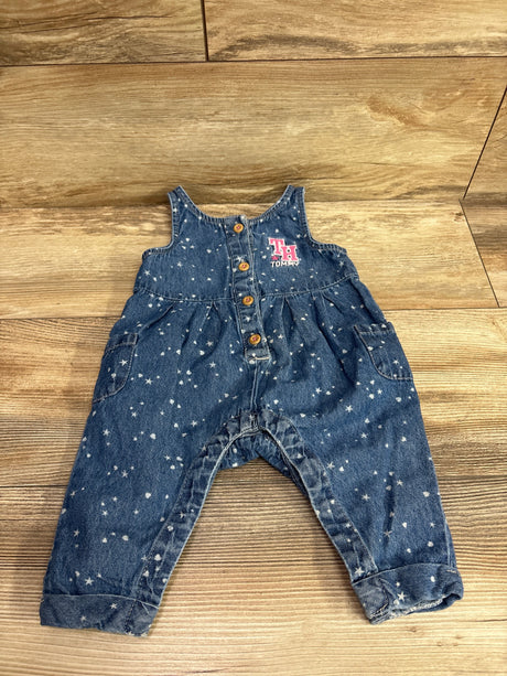 Front view of blue chambray sleeveless jumpsuit showcasing star print, button front, pockets, and Tommy logo on wood floor