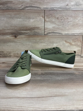 Pair of olive green kids canvas sneakers with white rubber soles and side zippers on wood floor