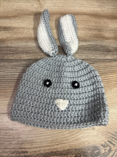 Grey crochet bunny hat for babies featuring white accents and black button eyes