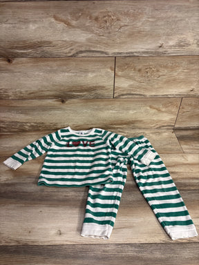 Green and white striped kids pajama set with 'LOVE' heart graphic on wooden background