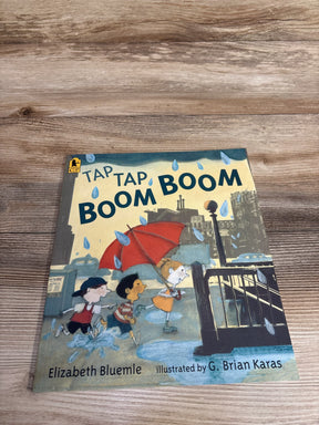Children running in rain with red umbrella on cover of Tap Tap Boom Boom book by Elizabeth Bluemle
