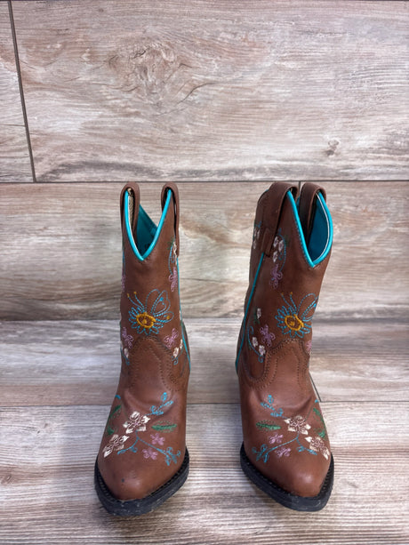 Front view of Shyanne floral-embroidered brown western boots showing turquoise lining and flower embroidery on wood floor