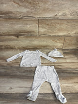 Flat lay of beige baby 3 piece set: long sleeve top, footed pants with animal faces, and knotted hat on wood floor