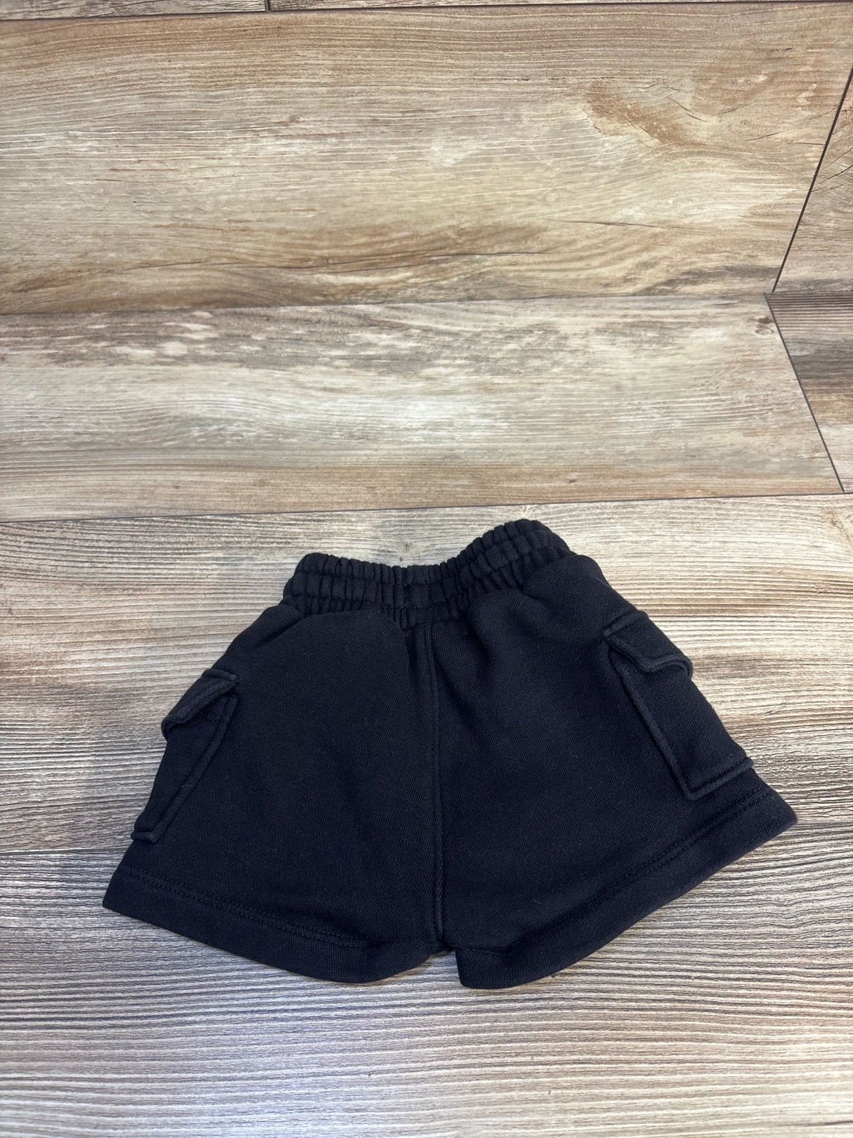 Black toddler shorts with side pockets on wood background, kids clothing resale