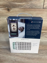 Nanit Breathing Band packaging for infants, shown with smartphone baby monitor app on wood surface