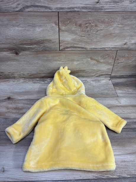 Top view of Hudson Baby yellow plush hooded duck robe for size 0-9 months showcasing hood and long sleeves with wood-look background