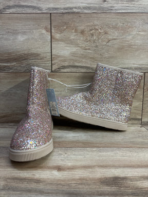 Kids pink glitter ankle boots with rubber soles on wood floor