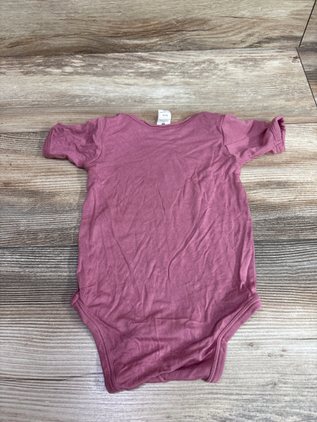 Pink Kate Quinn bamboo baby bodysuit for 3-6 months on a wooden background
