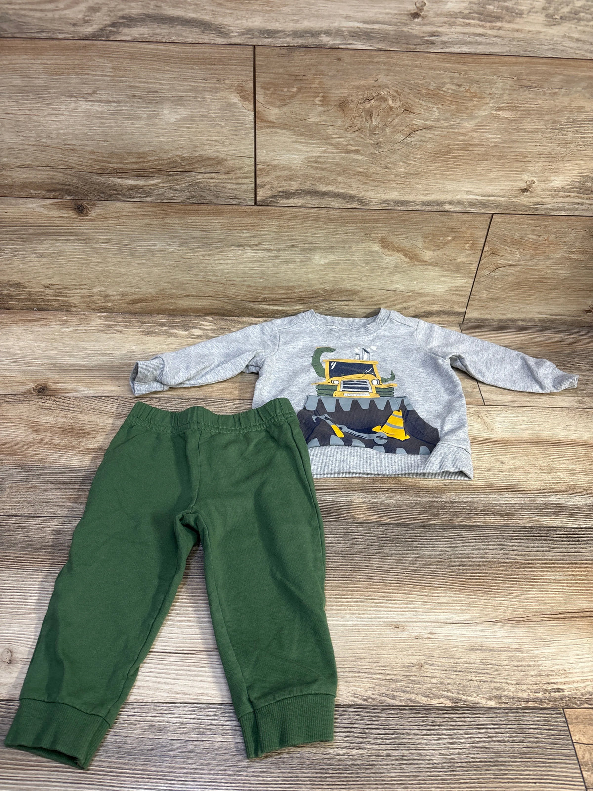 Top view of Carter’s 2pc Pullover Sweatshirt and Joggers Set showcasing a school bus graphic on a wood floor