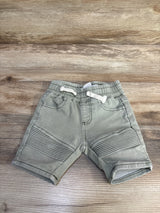 Front view of green Cotton On Baby moto shorts 6-12m showing ribbed knee panels and drawstring waist on wood background
