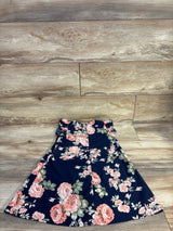 Flat lay of navy sleeveless floral girls dress size 5T showing A-line skirt and ruffled waist on wood background