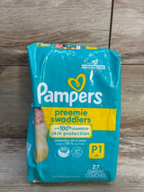 Front view of Pampers Preemie Swaddlers 27-count pack, teal packaging saying 'leakproof skin protection', on wood background