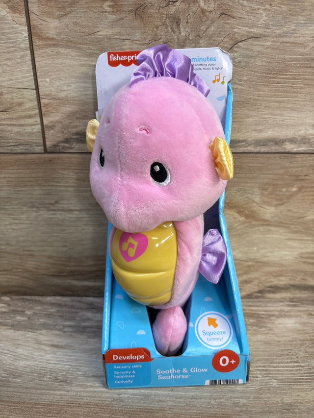 Front view of Fisher-Price Soothe & Glow Seahorse plush with pink body and yellow musical light-up belly in blue box