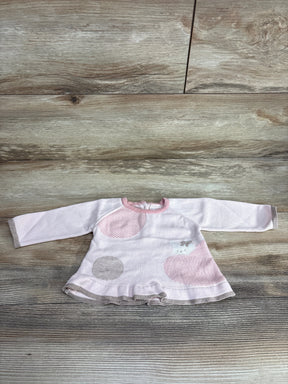 Pink and white long sleeve baby sweater dress with polka dots and ruffle hem on wood background