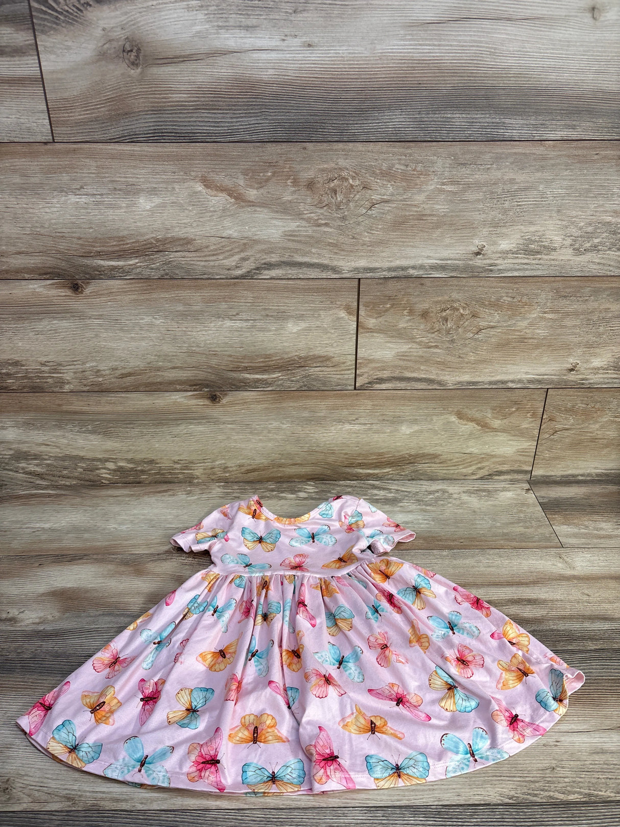 Front flat lay of pink Mila & Rose butterfly twirl dress size 3T showing short sleeves and full gathered skirt on wood background