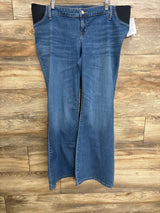 Front view of blue Isabel maternity flare jeans showing black side stretch panels and flared legs on wood background