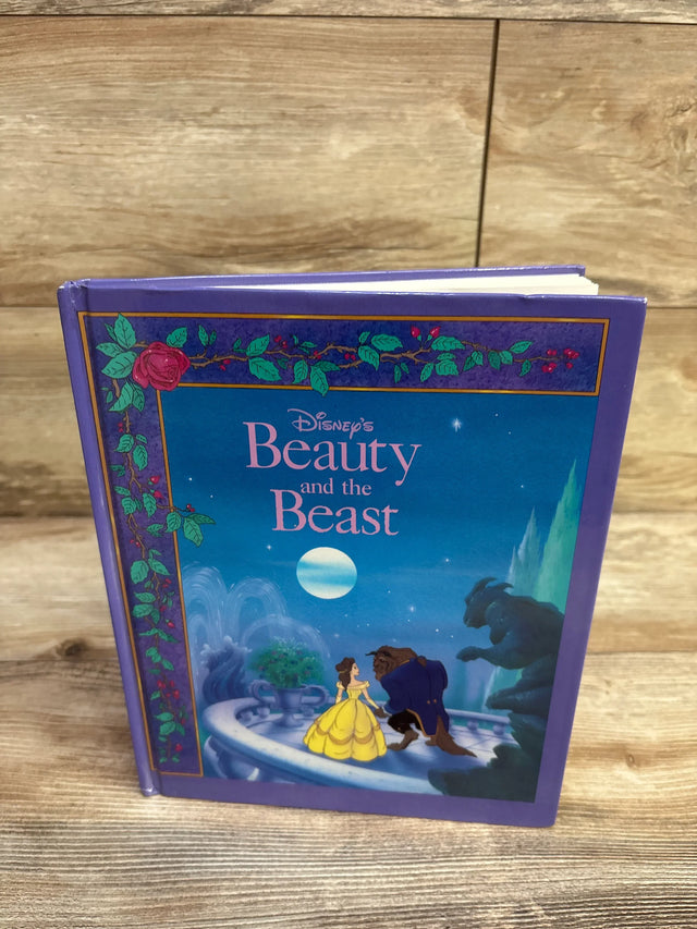 Front view of Disney Beauty and the Beast hardcover showing cover with Belle in yellow gown and Beast, purple cover on wood