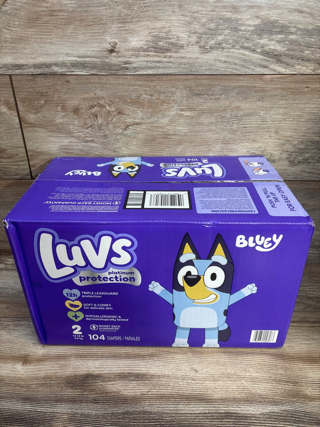 Front view of Luvs Platinum Protection size 2 box, 104 count, showing Bluey character on purple packaging on wood background